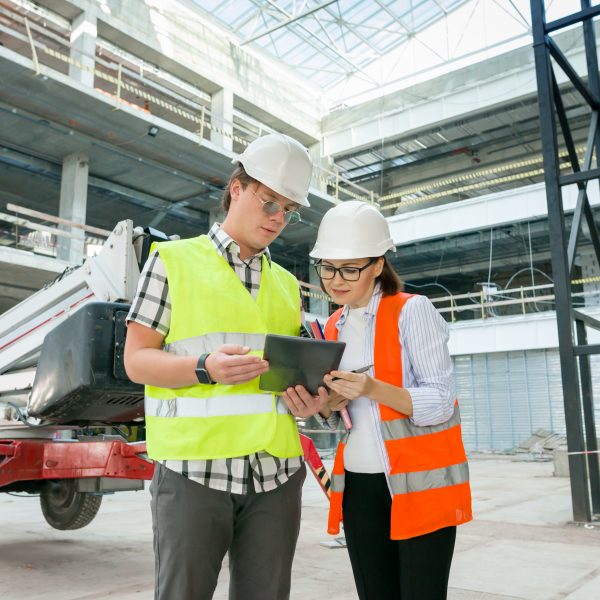 Industrial portrait of male and female engineers in construction of commercial administrative building